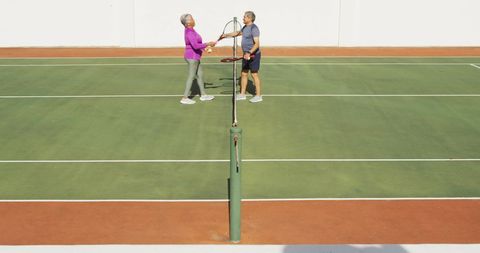 Senior Couple Celebrating on Tennis Court in Bright Day