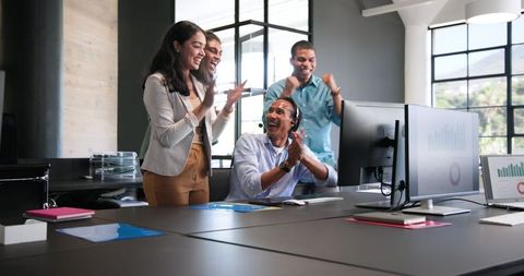 Diverse team celebrating successful business achievement in office