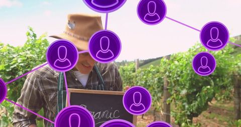 Vintner holding organic chalkboard while selling grapes in vineyard rustic sustainable farming
