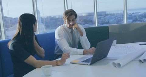 Business Colleagues Collaborating on Project with Laptop and Blueprints