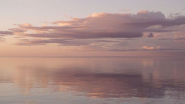 Serene Pastel Sunrise Over Tranquil Waters with Cloud Reflections