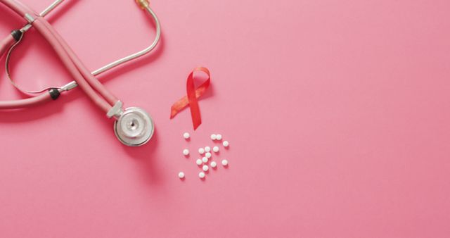 Image of stethoscope, pills and pink ribbon on pink background. health, prevention, medicine, symbols and cancer awareness concept.