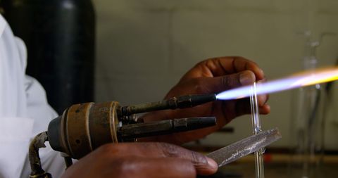 Skilled Artisan Blowing Glass in Workshop