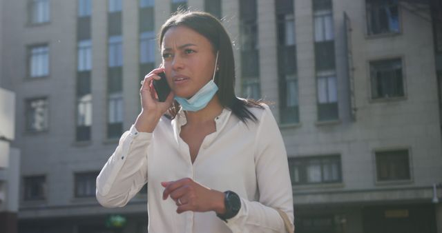 Concerned Woman Talking on Phone with Facemask in Urban Setting - Download Free Stock Images Pikwizard.com