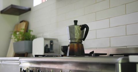 Classic stovetop espresso maker on gas burner in simple kitchen