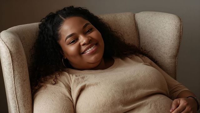 Reclining young woman smiling in neutral wingback chair, relaxed home portrait