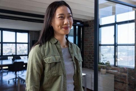 Confident Businesswoman Smiling in Modern Urban Office