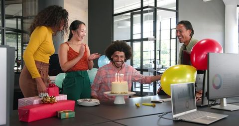 Cheerful office birthday celebration with multiethnic colleagues