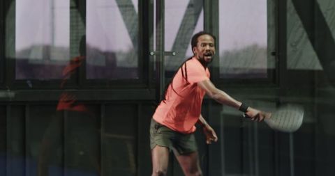 Athletic Man Playing Padel Tennis Indoors with Racquet in Action