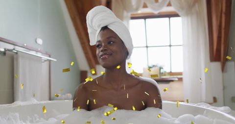 Joyful woman relaxing in luxurious home bath with confetti