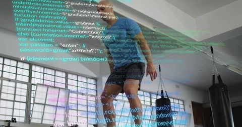 Man performing plyometric jump in gym with code overlay and punching bags