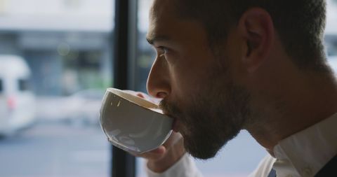 Businessman Sipping Coffee at Urban Cafe Table