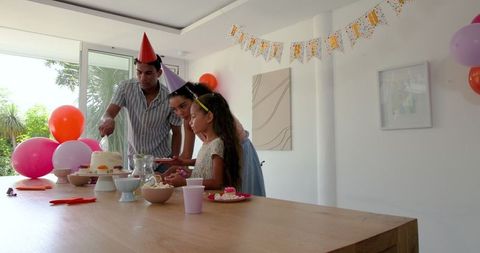 Family Celebrating Birthday at Home with Colorful Party Decorations
