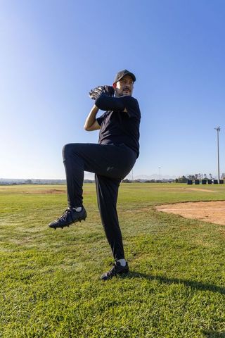 Mature Pitcher Winding Up on Mound During Sunny Baseball Practice