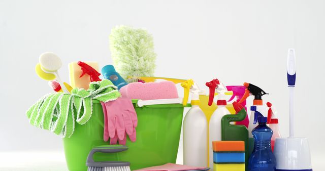 Image depicting a comprehensive set of house cleaning supplies including a green bucket filled with cleaning tools. Various colorful products such as sponges, spray bottles, brushes, and gloves are well-organized. Ideal for illustrating home care, housekeeping services, hygiene, household chores, and residential cleaning. Suitable for websites, advertisements, blogs on cleaning tips, and articles about maintaining a clean home environment.