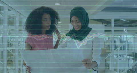 Diverse Businesswomen Analyzing Blueprint with Financial Graph Overlay