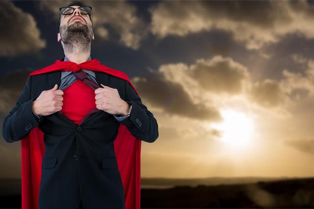 Businessman wearing a suit and red cape, tearing open his shirt to reveal superhero costume underneath. Dramatic sunset with clouds in the background. Ideal for concepts of leadership, motivation, transformation, and personal strength. Suitable for business presentations, motivational posters, and inspirational content.
