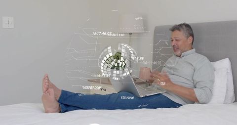 Mature man reclining on bed using laptop and coffee mug with futuristic hud overlay, calm vibe