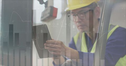 Asian Male Worker Analyzing Data in Warehouse with Digital Overlay