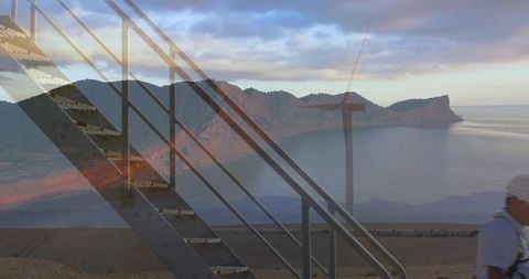 Diagonal metal staircase running along coastal cliff with bay double exposure