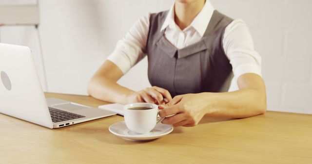 Businesswoman drinking coffee while working on laptop in office - Download Free Stock Images Pikwizard.com