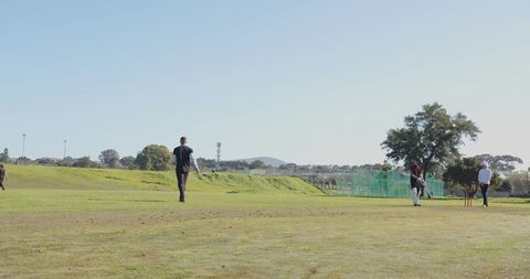 Cricketers Practicing on Sunny Park Day