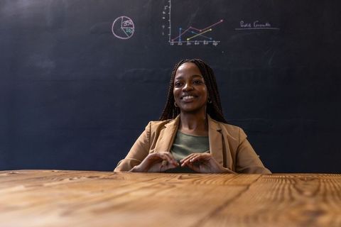 Professional woman teaching with chalkboard diagrams in classroom