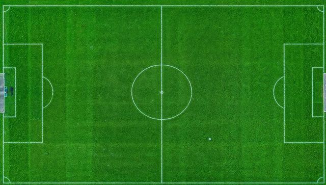 Aerial soccer field with regulation markings, goals and center circle on green turf