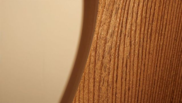 Curved oak veneer panel showing vertical grain and rounded cutout close-up texture warm