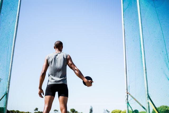 Rear view of athlete about to throw a discus in stadium
