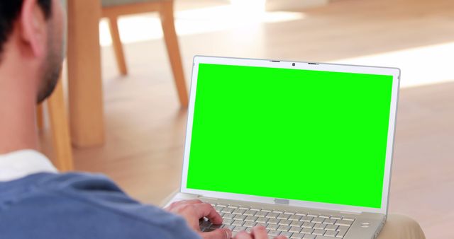 Person using laptop with green screen in home setting - Download Free Stock Images Pikwizard.com