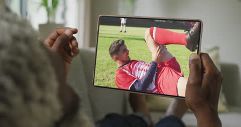 Afroamerican Watching Soccer Game on Tablet at Home