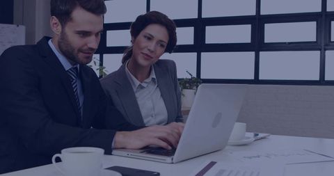 Business Professionals Collaborating on Laptop in Modern Meeting Room