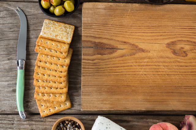 Crackers biscuits, ingredients and chopping board on wooden background