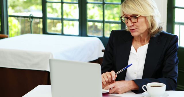 Mature Businesswoman Working on Laptop in Cafe - Download Free Stock Images Pikwizard.com