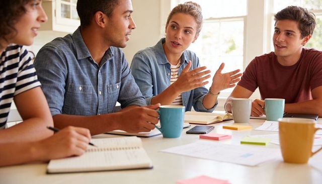 Young professionals collaborating over coffee and notes in bright casual team brainstorming
