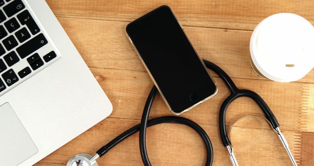 Stethoscope, Smartphone, Coffee Cup, and Laptop on Wooden Desk - Download Free Stock Images Pikwizard.com