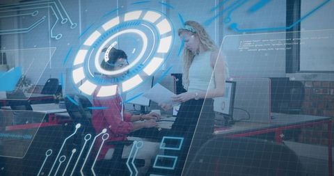 Woman holding papers talking to seated colleague with futuristic HUD overlay in open office