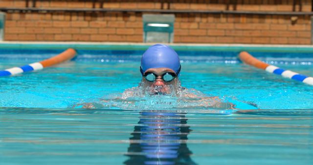 Swimmer Wearing Blue Cap and Goggles Practicing in Outdoor Pool - Download Free Stock Images Pikwizard.com