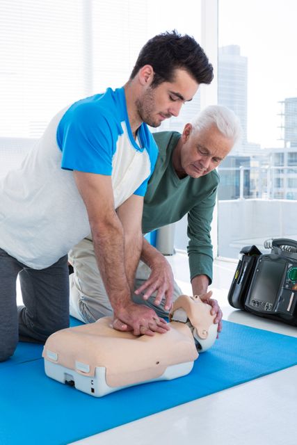 Paramedic training cardiopulmonary resuscitation to man in clinic
