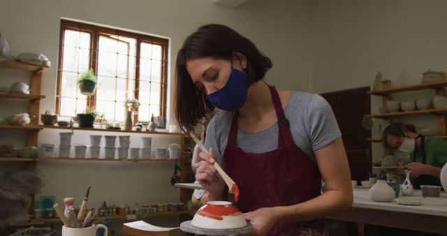 Woman Glazing Ceramics in Art Studio, Wearing Protective Face Mask - Download Free Stock Images Pikwizard.com