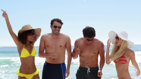 Joyful Friends Having Fun at Beach Party Under Sun