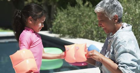 Grandmother and Child Bond Over Pool Play with Water Wings