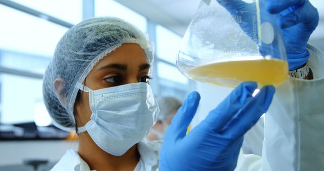 Female Scientist Examining Liquid in Beaker - Download Free Stock Images Pikwizard.com