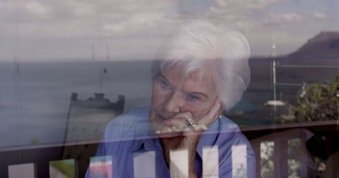 Contemplative Senior Woman Gazing Through Window at Home