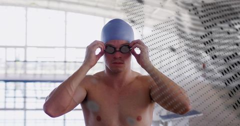 Competitive swimmer adjusting goggles on pool deck preparing for training session