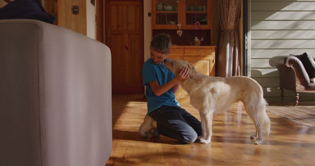 Happy caucasian boy playing with his dog at home. Pets, domestic life, childhood and lifestyle, unaltered.