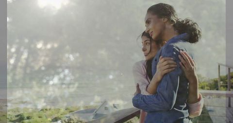 Mother and Daughter Embracing on Balcony Overlooking Serene Landscape
