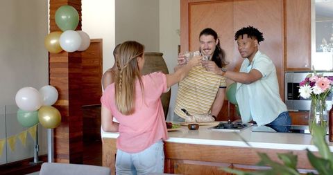 Friends Toasting in Kitchen While Celebrating Party Gathering