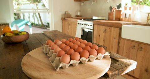 Carton of Brown Eggs on Rustic Wooden Kitchen Table